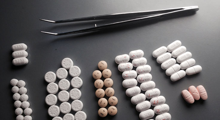 petite pince avec différentes types de pilules pour illustrer comment fonctionne une pharmacie