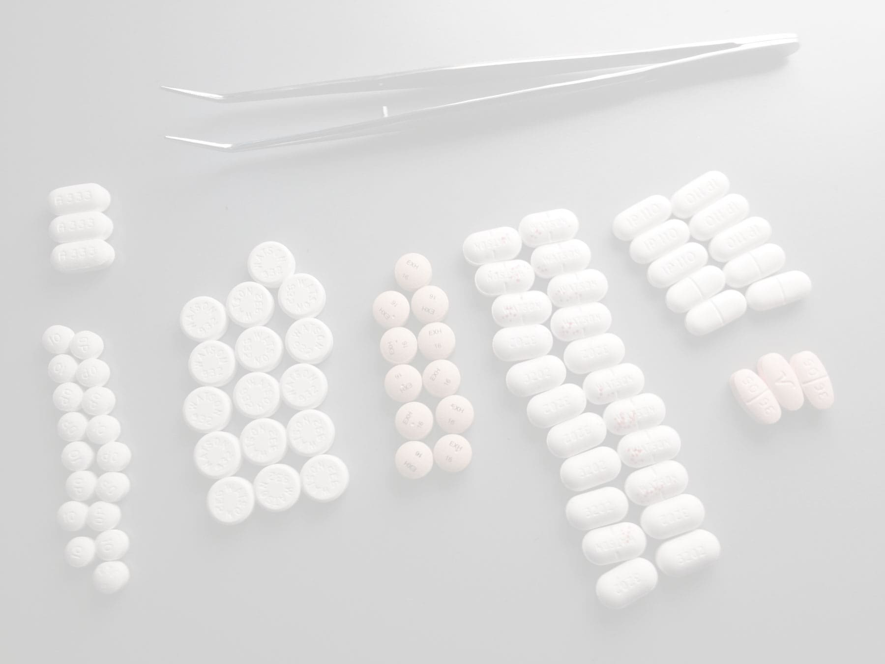 petite pince avec différentes types de pilules pour illustrer comment fonctionne une pharmacie